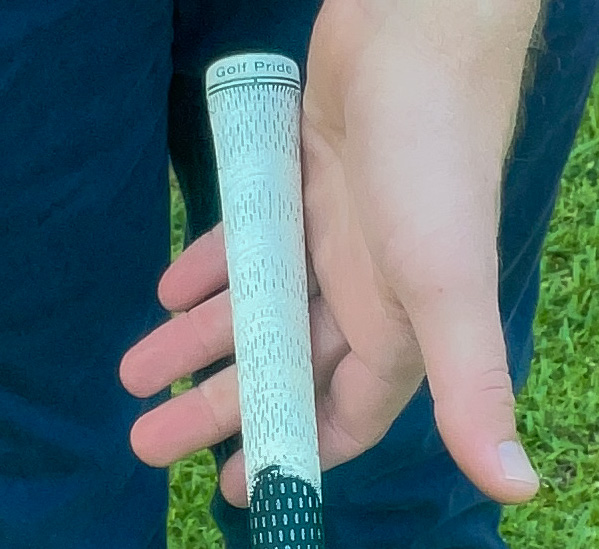 A golfer demonstrates the beginning of a proper strong golf grip with the left hand. 
