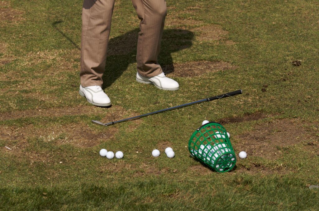 Golfer practicing his golf swing on a driving range. 