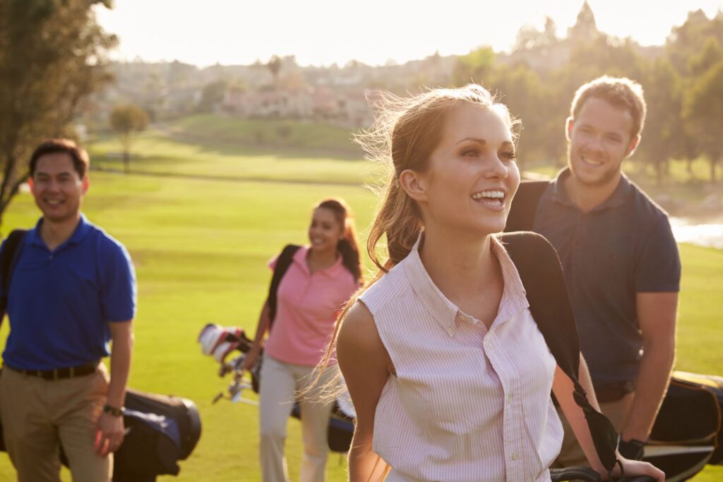 Four golfers playing a round of golf on a golf course. 