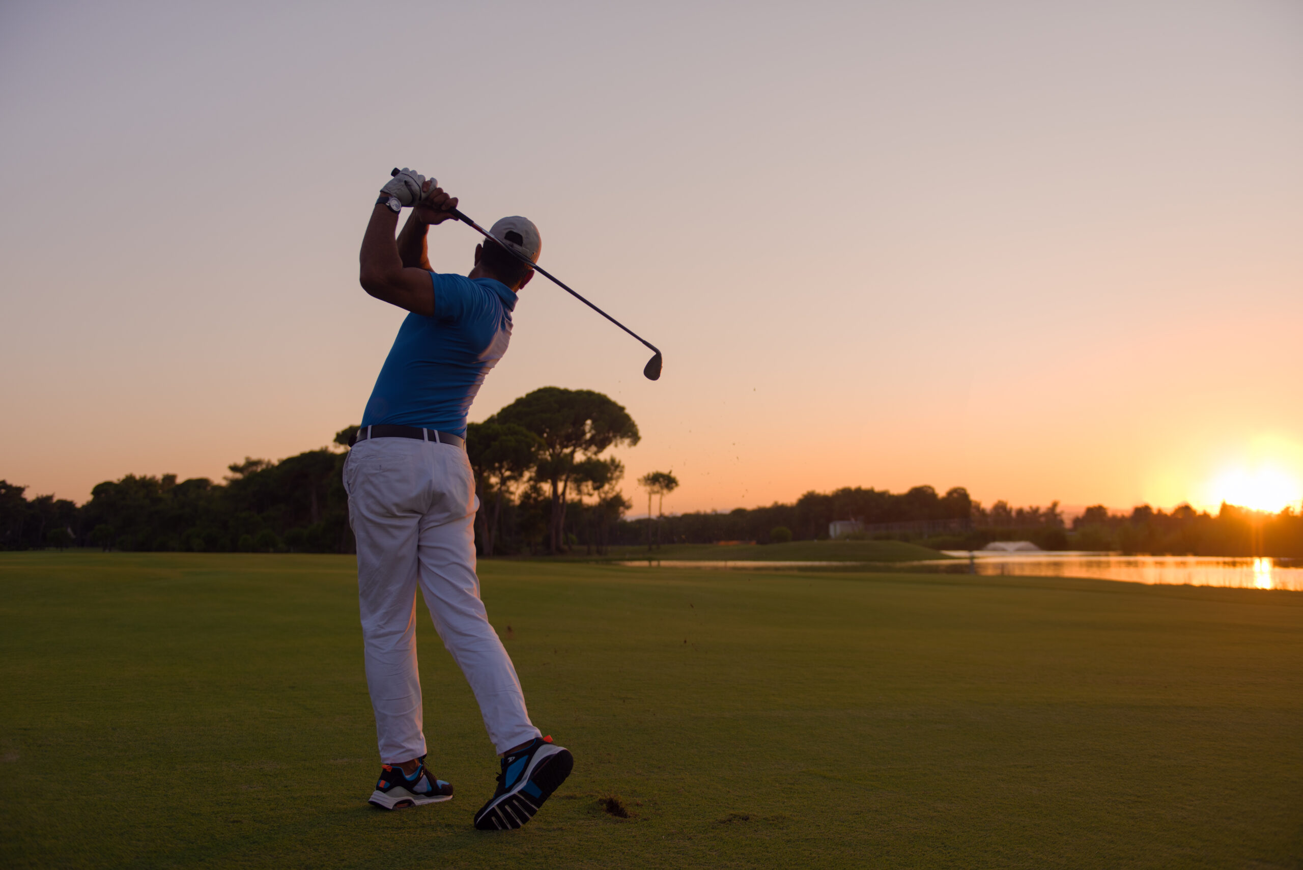 Man hitting golf shot at a golf course.