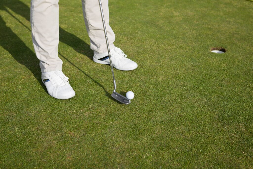 A golfer putting on a golf green. 