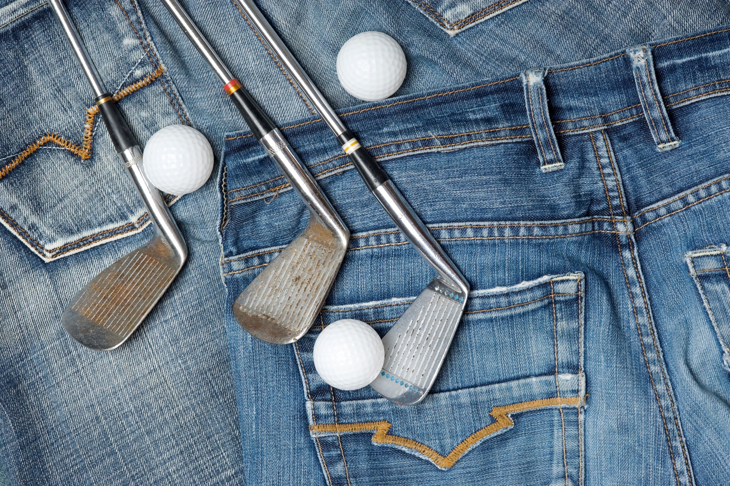 Jeans with golf clubs laying on top