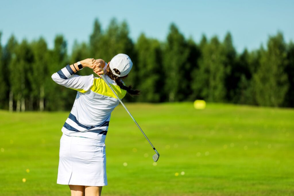 A female golfer hitting a shot on the golf course.