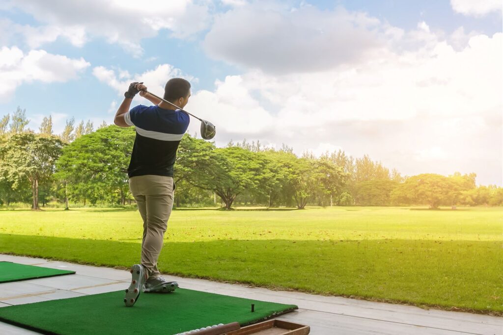 A golfer practicing on a driving range. 