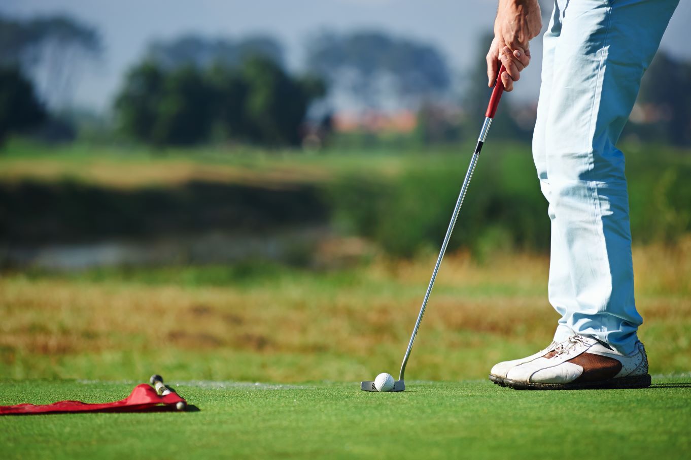 A golfer putts for a birdie during a round of golf.