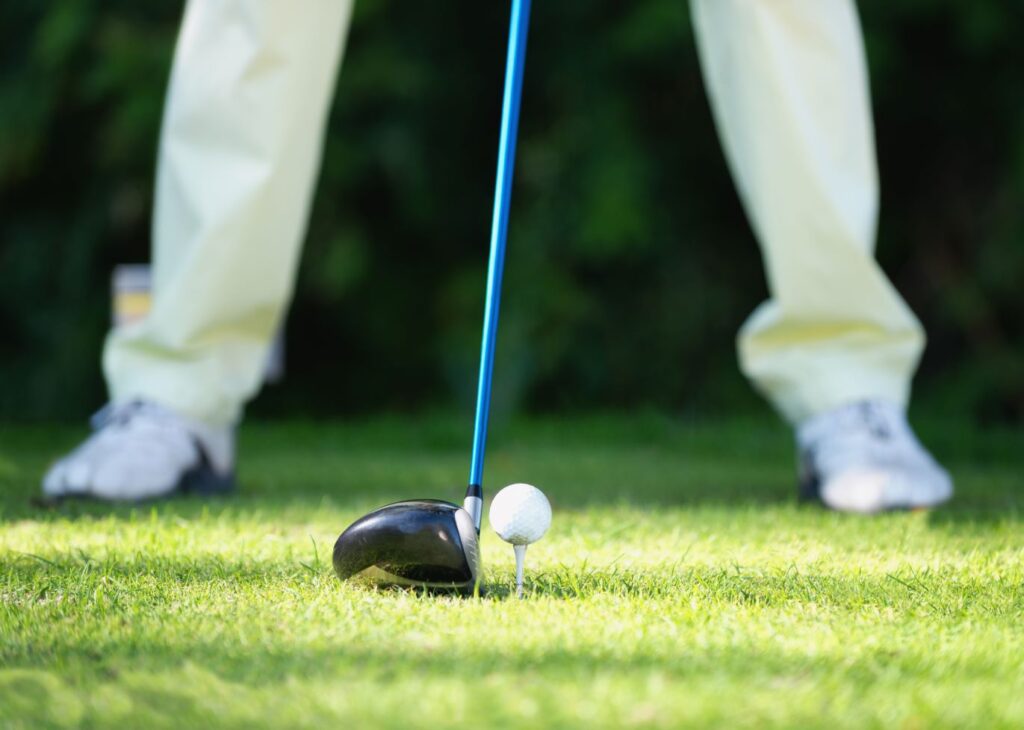 A golfer hitting a driver while working on his golf swing. 