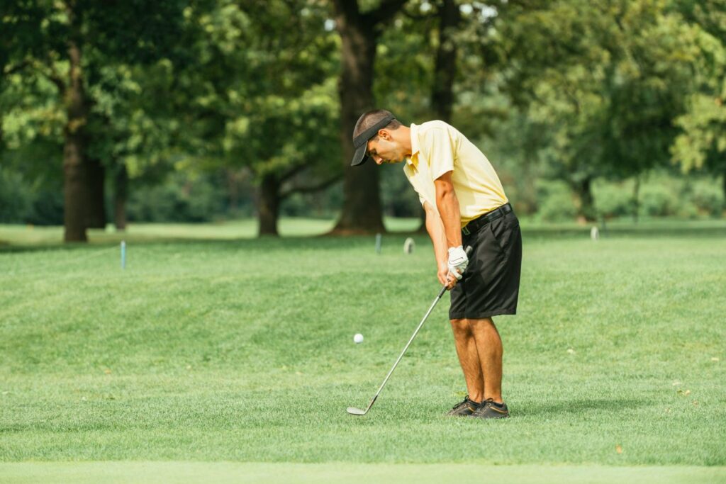 A golfer practicing a chipping drill at a golf practice facility. 